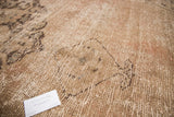 Muted pinkish-brown distressed pile with foundation showing on vintage Oushak carpet.