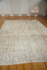 Modern distressed Oushak rug with faded floral palmettes and aged patina.