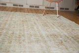 Textured distressed surface of Oushak rug with muted palmette designs.