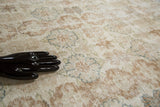 Oushak rug texture revealing faded wooded and blue palmette designs, with hand.