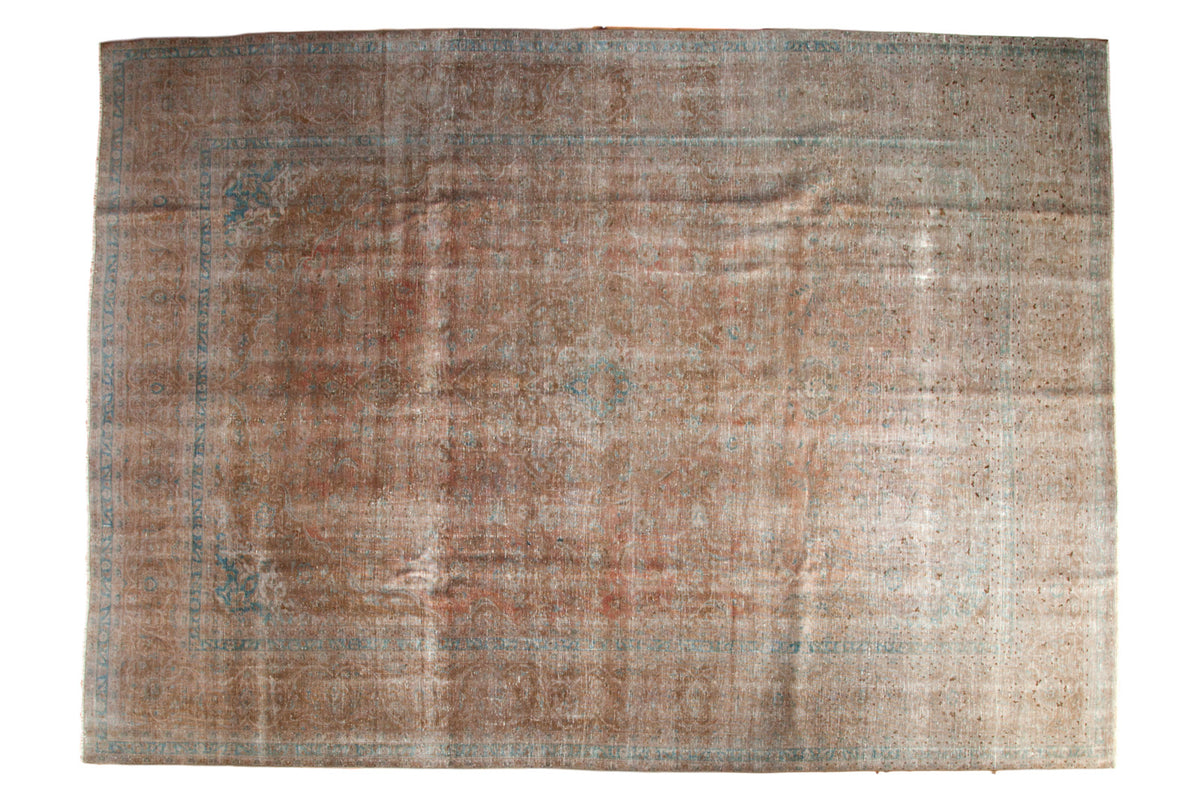 Distressed Vintage Kashan carpet, an intricate medallion design in muted bronze, rose, and aqua.