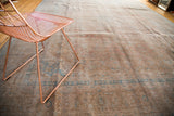 Distressed vintage Kashan carpet displaying faded bronze-rose and aqua traditional Persian patterns.