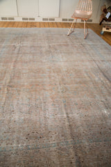 Distressed texture of a vintage Kashan rug showing muted bronze blush and aqua.