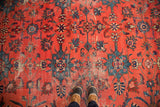 Distressed Persian Mahal rug detail with cherry red field and teal blue floral palmettes.
