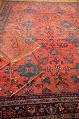 Distressed Mahal carpet, watermelon red field with teal palmettes and floral blossoms.