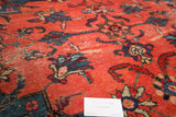 Distressed texture of vintage Mahal rug, watermelon red field with teal and blush floral motifs.