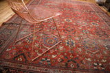 Bold cherry red distressed Mahal carpet, intricate blue and gold patterns, visible foundation.