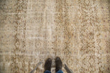 Worn texture of distressed Oushak carpet, with muted ivory, gold, and grey floral patterns.