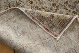 Hand-knotted Oushak rug corner showing distressed pile, floral border, and woven foundation.
