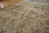 Textured detail of distressed vintage Oushak carpet showing faded vinery and floral motifs.
