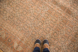Textured distressed pile of a vintage Tabriz rug with faded rust and brown tones.