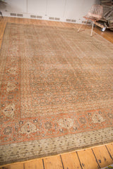 Distressed Tabriz carpet corner, faded rust and brown pile with visible knot heads.
