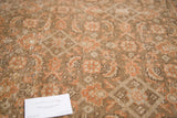 Distressed texture of subdued brown and faded rust floral patterns on a vintage Tabriz rug.