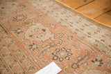Faded rust and subdued brown patterns on the distressed vintage Tabriz pile.