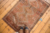 Vintage Kurd rug with geometric triple diamond medallion, floral pomegranates, and wave border.