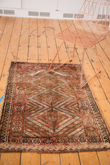 Triple diamond medallion, pomegranate, and wave borders on a vintage Kurdish rug.