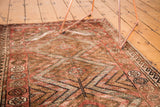 Kurd rug's triple diamond medallion, geometric patterns, and pomegranate border.
