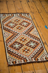 Saffron, tangerine, and charcoal geometric patterns on a vintage Turkish Kilim rug.