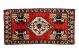 Hand knotted Vintage Oushak rug, cherry red field, ivory medallion, charcoal plant motifs.