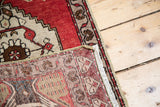 Vintage Oushak rug's hand-knotted foundation, showing red, beige yarns and white fringe.