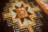 Vintage Oushak rug pile with tribal starburst design, tangerine, saffron, and fringe.