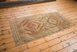 Distressed vintage Afghani runner with terracotta geometric patterns and a muted beige field.
