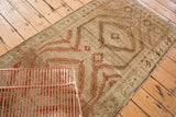 Geometric medallion details with distressed soft sage, beige, and terracotta tones.
