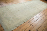 Subtle tone-on-tone floral field on a vintage Oushak runner in antique ivory and sea foam green.