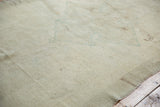 Soft ivory hand-knotted pile of a vintage Turkish Oushak runner with subtle floral motifs.