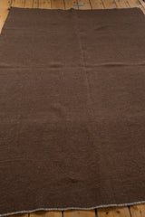 Rich chocolate brown hand woven Kilim rug showcasing natural wool texture and secured edge.