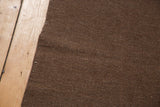 Moroccan Kilim rug with chocolate brown natural wool texture and hand-finished edge.