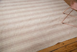 Hand woven Turkish flatweave carpet texture with varied ivory and beige stripes.