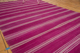 Angled view of repeating mauve and silver banded stripes on a Moroccan Kilim.