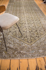Distressed vintage Hamadan runner's corner, showing faded Herati pattern, worn pile, and fringe.