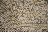 Distressed Hamadan Herati pattern in muted gold, ivory, green, and charcoal with worn texture.