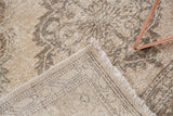 Hand knotted vintage Sparta rug's distressed ivory, beige pile, fringe, and tight woven back.