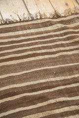 Striated beige and dark brown stripes on vintage Moroccan Kilim's flat weave texture.