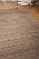 Hand-woven texture and striated natural brown and beige tones of the vintage Moroccan Kilim rug.