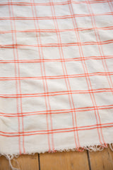 Vintage Moroccan textile, ivory and peach rose plaid pattern, with a frayed edge.