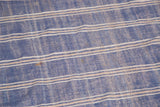Detail of hand-woven denim blue Moroccan Kilim, ivory and beige stripes, light staining.