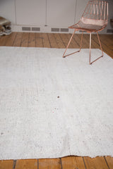 Ivory vintage Turkish flatweave carpet displaying subtle charcoal speckling and small secured hole.