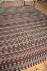Striated flat weave of a vintage Moroccan Kilim, with natural browns and bold red end stripes.