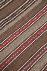 Textured detail of vintage Moroccan Kilim, featuring striated brown, beige, and red.