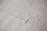 Hand woven hemp grainsack carpet texture with subtle beige tones and visible seam joining strips.