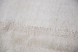 Close-up of the hand woven vintage grainsack carpet showing a natural fiber stitched seam.