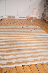 Secured end of vintage Moroccan flatweave, with banded ivory and caramel stripes.