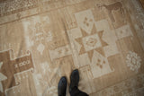 Vintage Oushak rug runner with geometric starburst, animal motif, and abrash in ivory, sand, bronze.