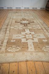 Bronze and ivory starburst medallion with serrated border on a vintage Oushak rug.