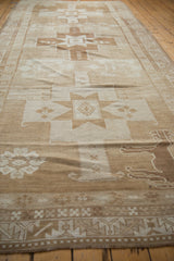 Geometric border patterns in ivory and sand on a vintage Oushak rug runner's edge.
