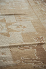 Hand-knotted pile texture with sand and ivory geometric motifs on a vintage Oushak runner.